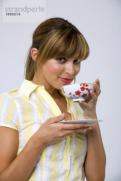 Junge Frau trinkt Tee  Porträt  Nahaufnahme