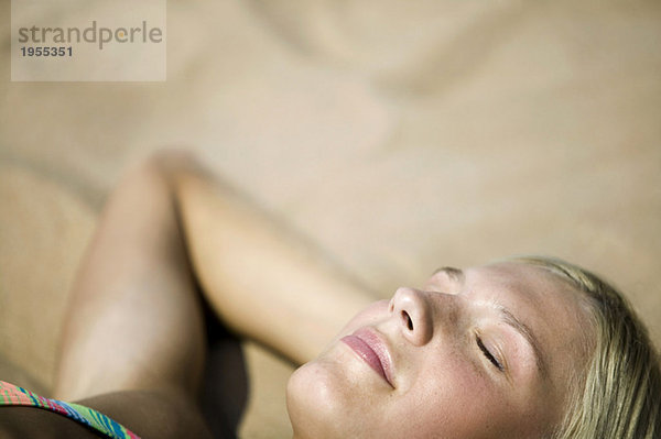 Frau entspannt am Strand  Augen geschlossen  (Fokus auf Vordergrund)