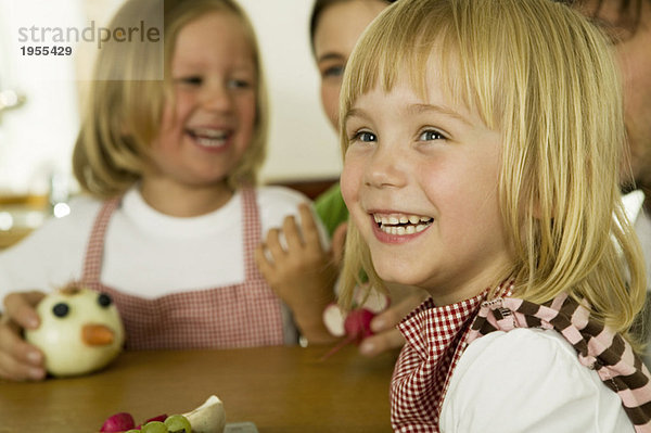 Eltern mit Kindern (2-4) spielen in der Küche  lächelnd