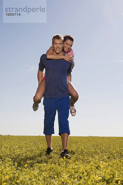 Junger Mann mit Frau auf dem Rücken