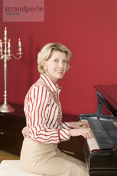 Reife Frau am Klavier  lächelnd  Portrait