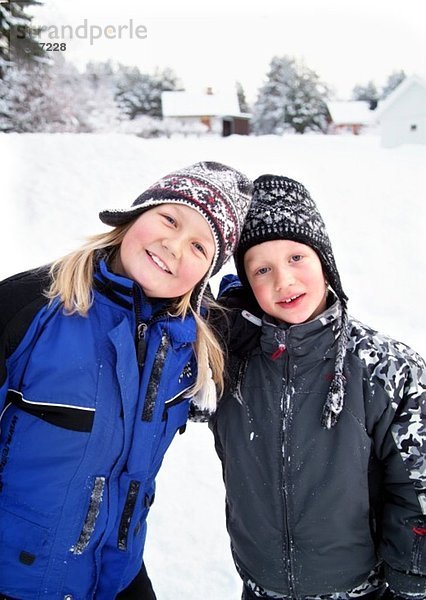 Mädchen und Junge spielen im Schnee