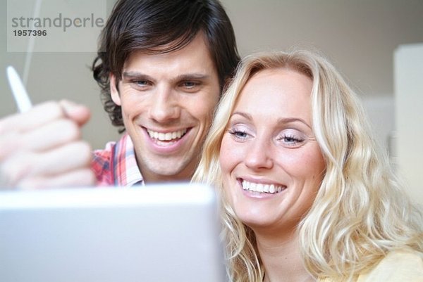 Glückliches junges Paar vor dem Computer