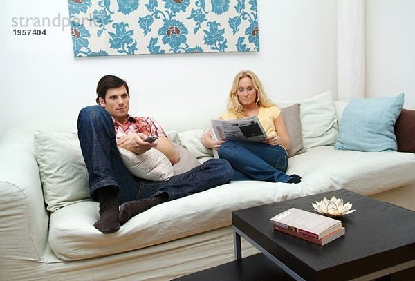 Junges Paar zu Hause in der Couch sitzend