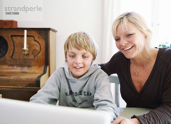 Mutter und Sohn benutzen den Computer gemeinsam