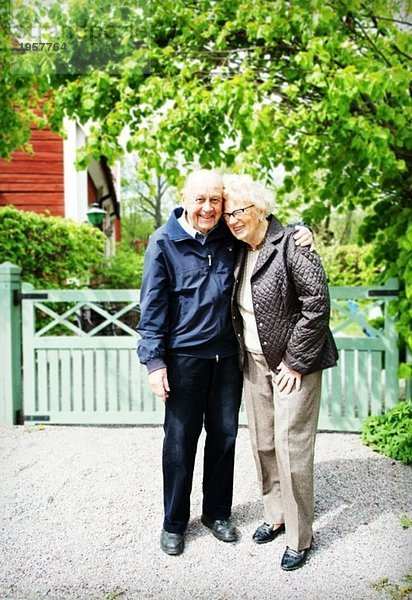 Älteres Paar vor den Toren eines Hauses