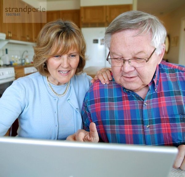 Paar sitzend mit Computer