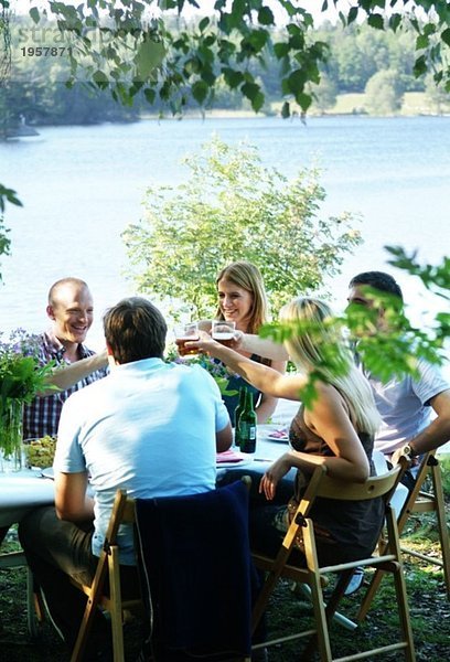 Toasting beim Abendessen im Sommer