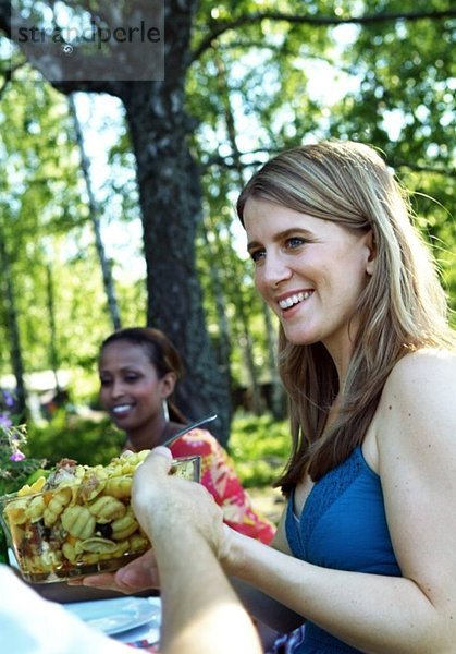 Mädchen  das Salatschüssel über den Esstisch führt