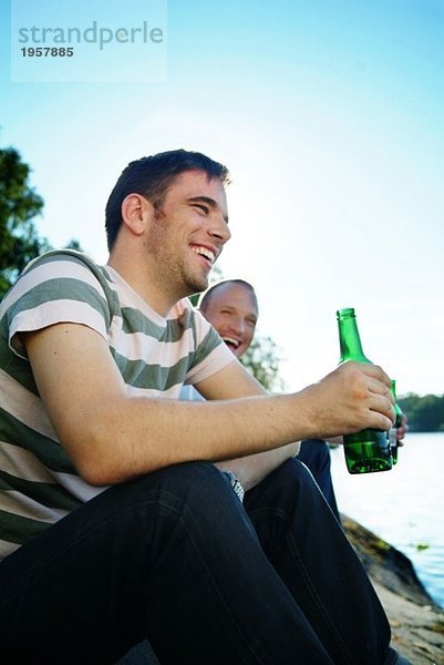 Zwei Freunde beim kalten Bier auf einem Felsen