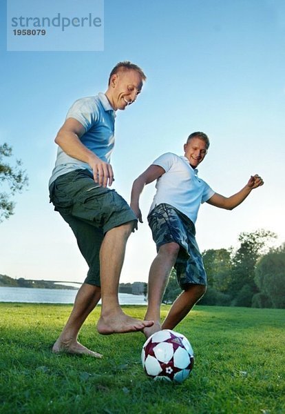 Zwei Jungs spielen Fußball im Park