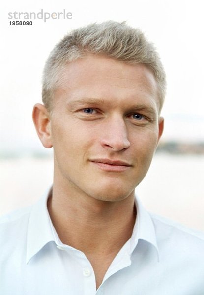 Porträt eines blonden jungen Mannes in weißem Hemd