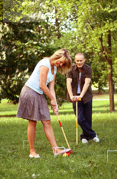 Mädchen und Mann beim Golfen