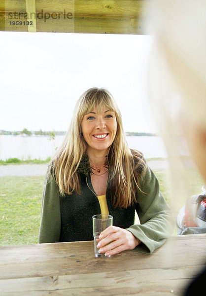 Frau sitzend mit einem Glas