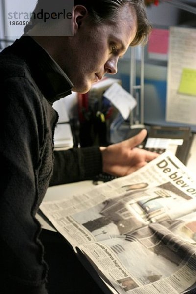 Junger Mann mit Zeitung