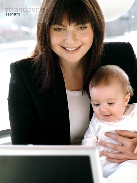 Junge Frau mit Kind und Computer