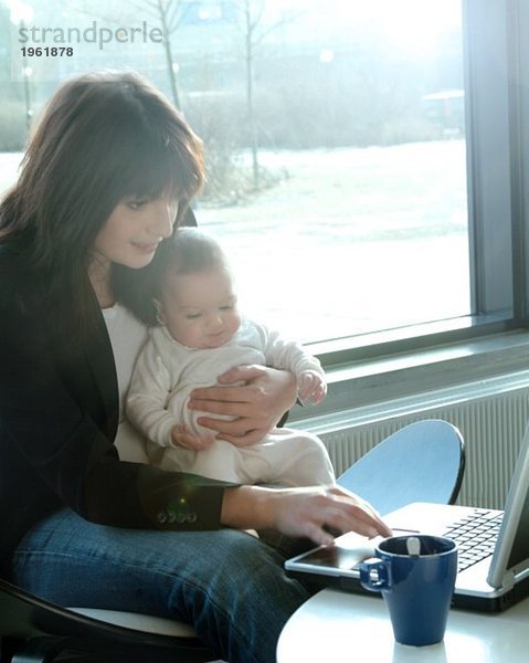 Mutter mit Baby und Computer