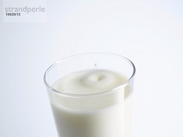 Ein Glas Milch mit einem Milchtropfen