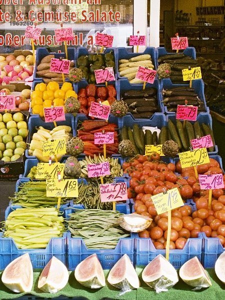 Gemüse und Obst mit Preisschildern in Kisten
