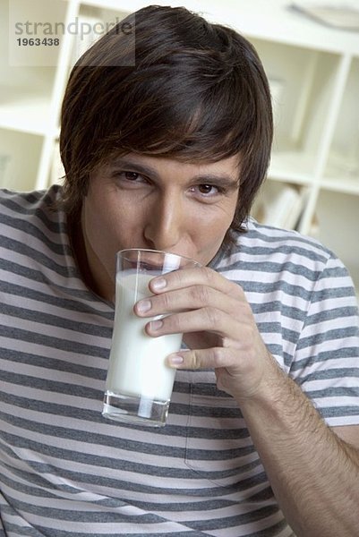 Junger Mann trinkt ein Glas Milch