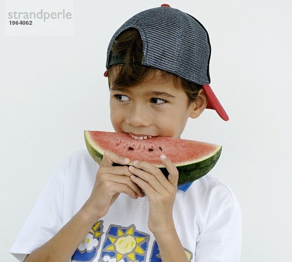 Junge beisst in ein Stück Wassermelone