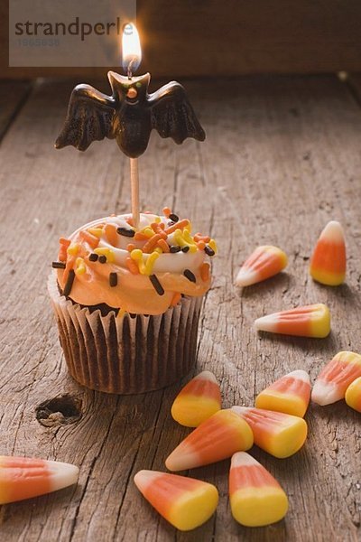 Cupcake mit Fledermauskerze und Candy Corn zu Halloween (USA)
