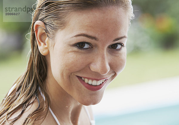 Frau mit nassen Haaren an Pool  Porträt