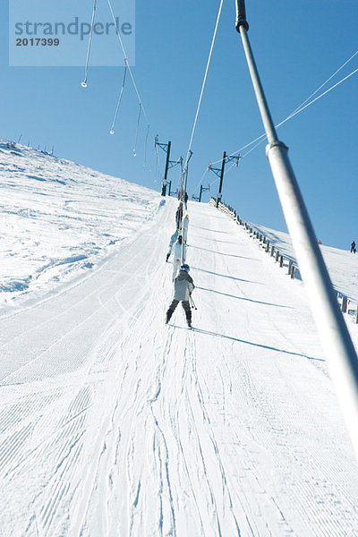 Junge Skifahrer mit Skilift auf der Piste  Tiefblick