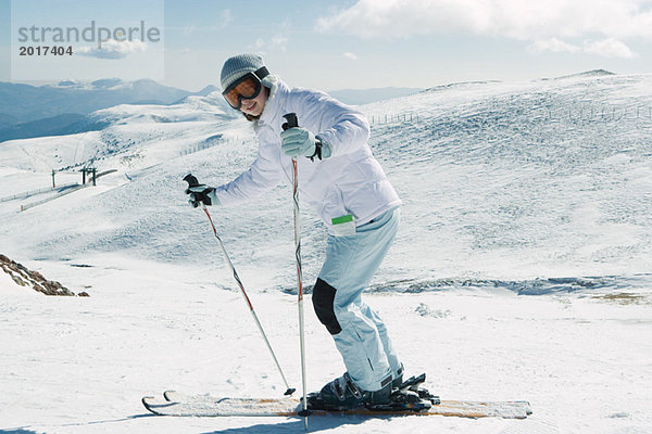 Junger Skifahrer lächelnd vor der Kamera  Ganzkörperporträt