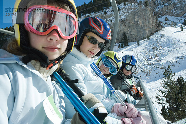 Junge Skifahrer auf dem Sessellift  lächelnd vor der Kamera