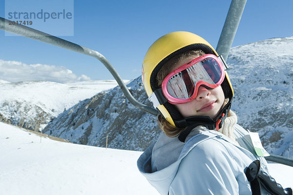 Teenagermädchen am Skilift  mit Brille und Helm  Blick in die Kamera  Porträt