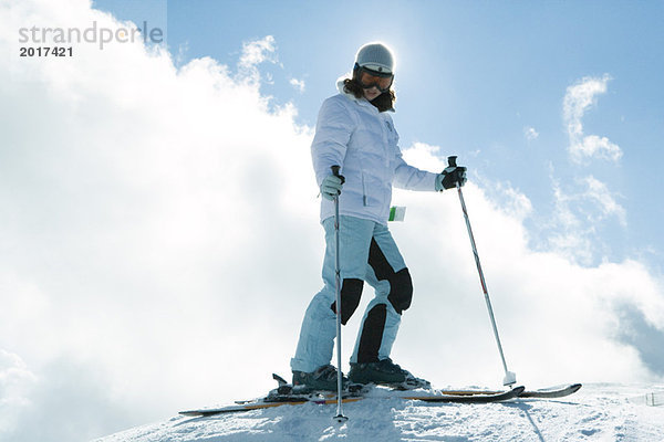 Junger Skifahrer auf der Piste  Portrait in voller Länge  Blick in die Tiefe