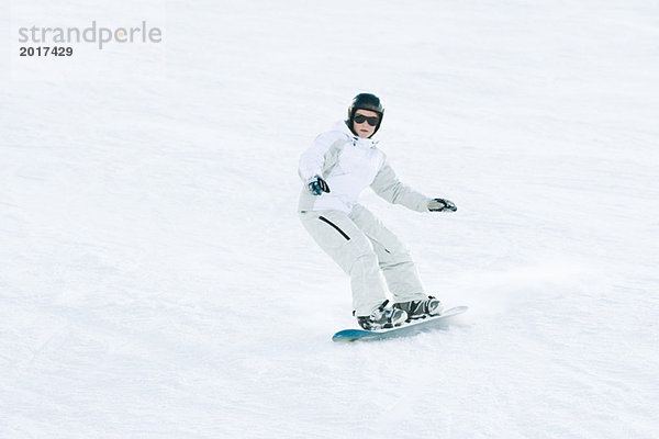 Teenage Girl Snowboarding auf der Skipiste  volle Länge