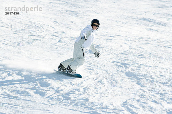 Teenage Girl Snowboarden auf der Piste  volle Länge