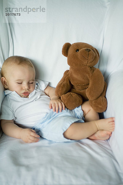 Baby schläft im Sessel mit Teddybär  Portrait