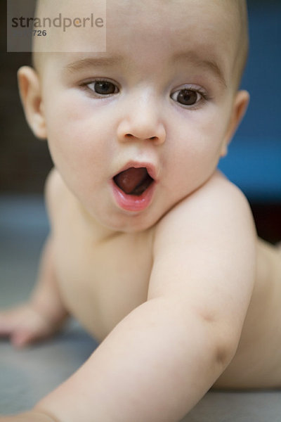 Baby auf dem Boden liegend  Mund weit geöffnet