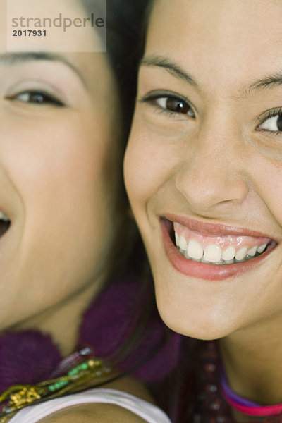 Zwei junge Freunde lächeln gemeinsam vor der Kamera  von Wange zu Wange  Blick in den Ausschnitt