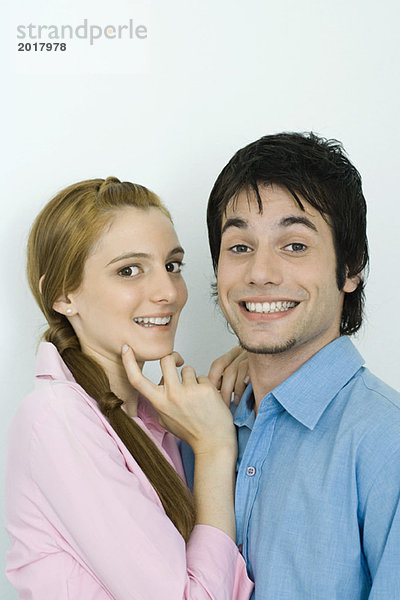 Junges Paar lächelt gemeinsam vor der Kamera  Porträt