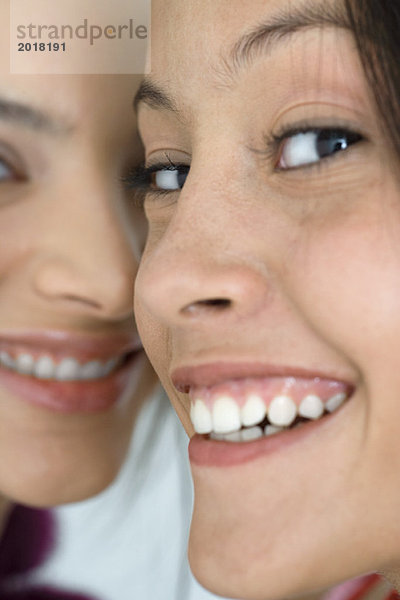 Zwei junge Freundinnen lächelnd vor der Kamera  extreme Nahaufnahme der Gesichter  beschnitten