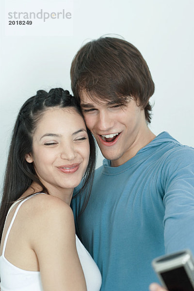 Junges Paar posiert für Foto  Mann hält Digitalkamera aus  Porträt