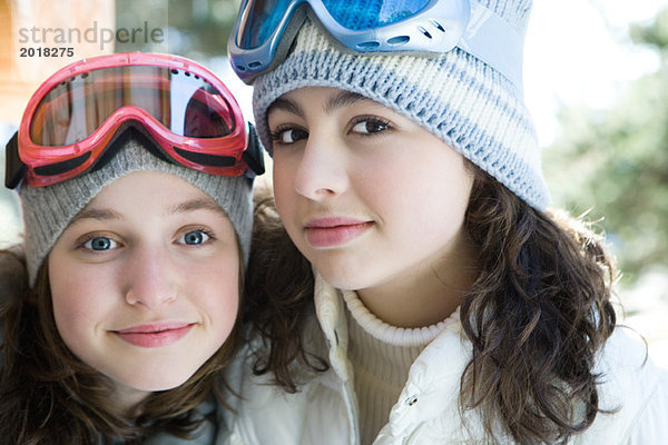 Zwei junge Freunde mit Strickmützen und Skibrille  lächelnd vor der Kamera  Porträt