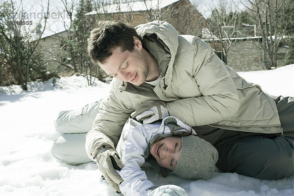 Zwei Freunde beim Roughhousing im Freien im Schnee