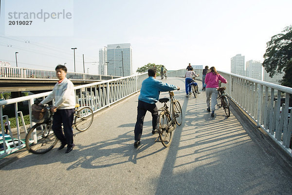 China  Provinz Guangdong  Guangzhou  Radfahrer überqueren Brücke