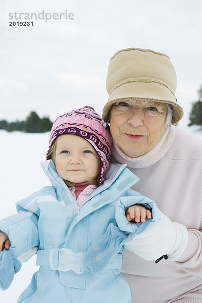 Großmutter und Enkelin lächelnd  in Winterkleidung  Portrait