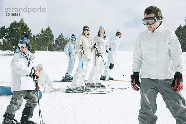 Gruppe junger Skifahrer auf Schnee stehend