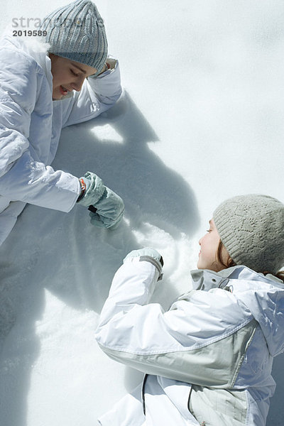 Zwei Teenagermädchen beim Malen im Schnee