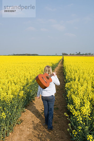 Frau im Feld mit Gitarre