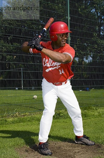 Ein Baseballspieler hält einen Baseballschläger.