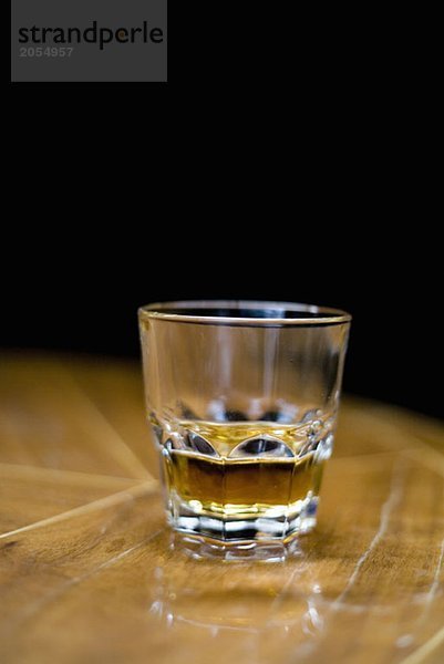 Ein Glas Whiskey auf einem Tisch