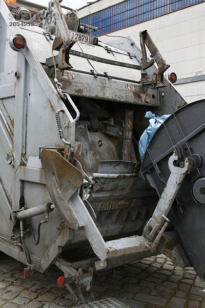 Ein Müllwagen holt einen industriellen Mülleimer ab